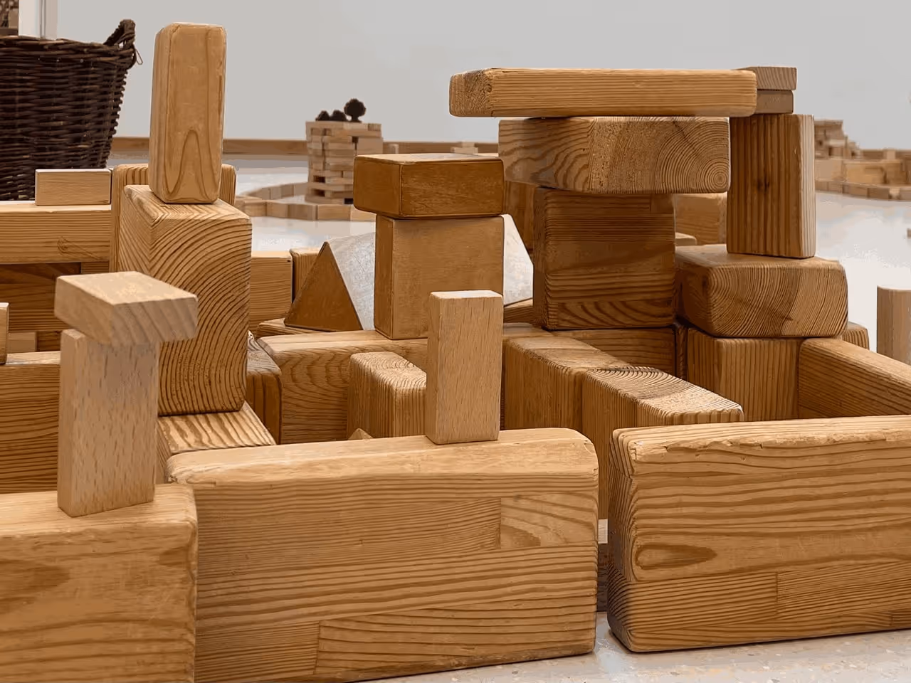 Bauwerk aus unbehandelten Holzbausteinen, zu Türmen und Brücken gestapelt.