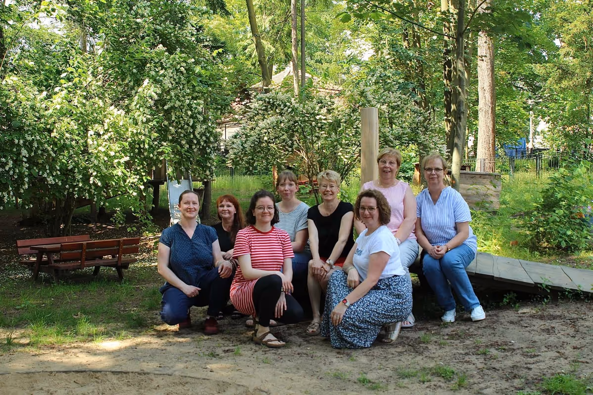 Das Team von KiK e.V. – Kinder in Kindertageseinrichtungen – im Außengelände einer Kita.